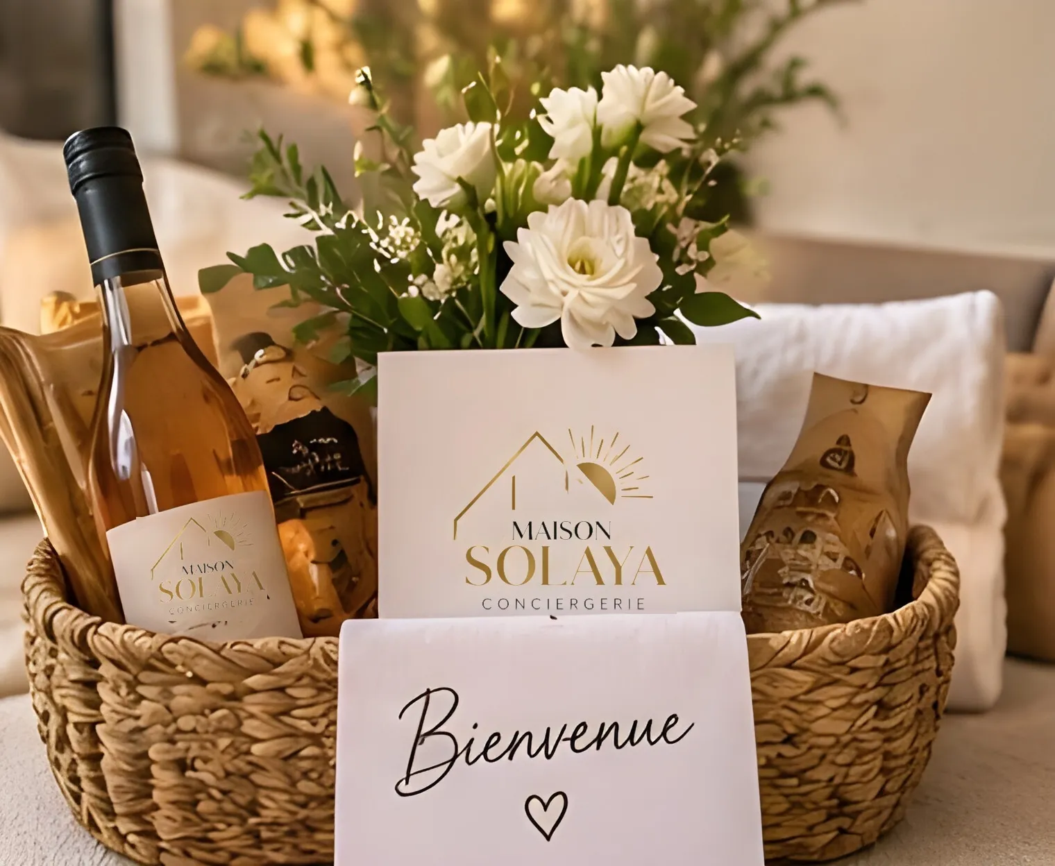 Panier de bienvenue avec vin, fleurs blanches et carte Bienvenue